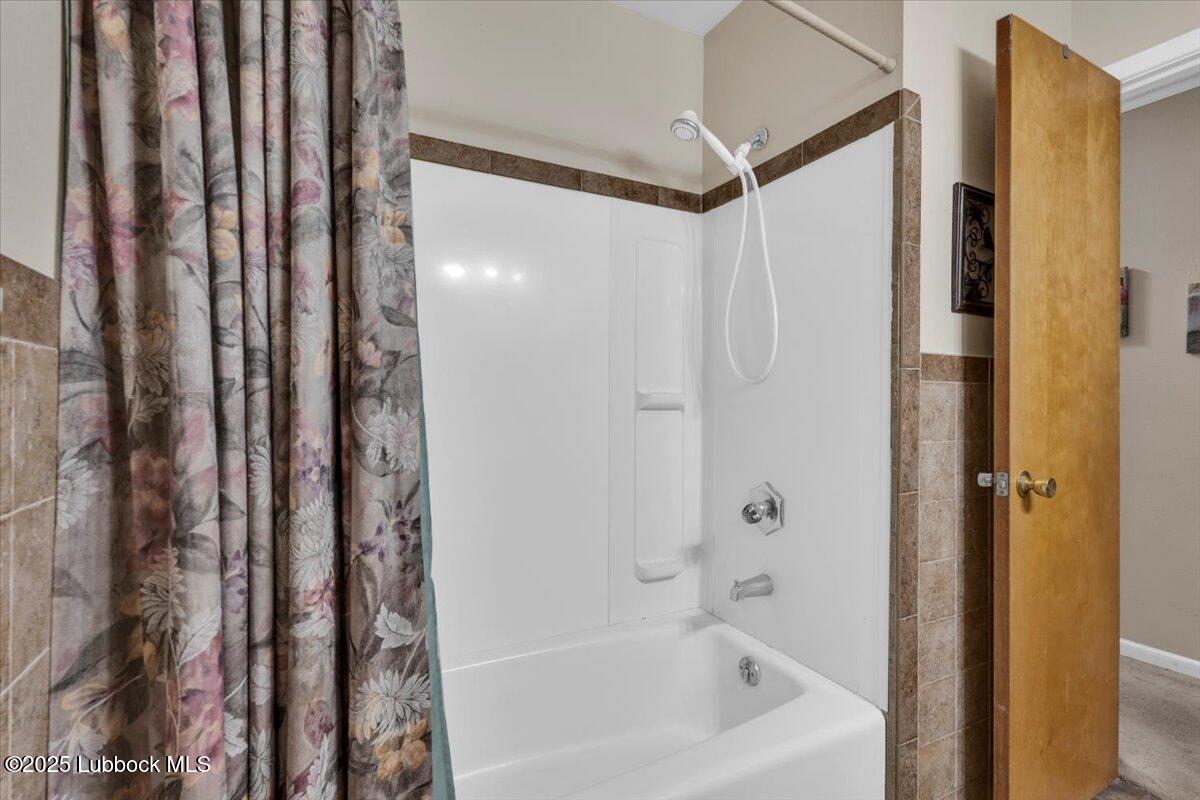 1405 3rd Street Plains, TX 79355 - Photo 13 of 19 a bathroom with a bathtub and shower