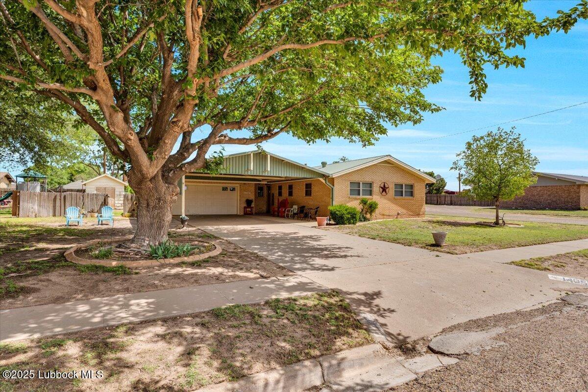 1405 3rd Street Plains, TX 79355 - Photo 16 of 19 a front view of a house with a yard and garage