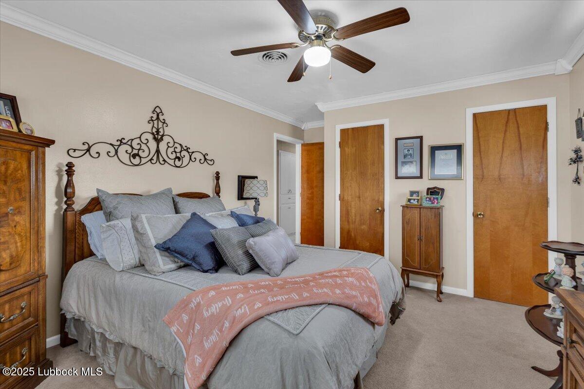 1405 3rd Street Plains, TX 79355 - Photo 10 of 19 a bedroom with a large bed and a ceiling fan