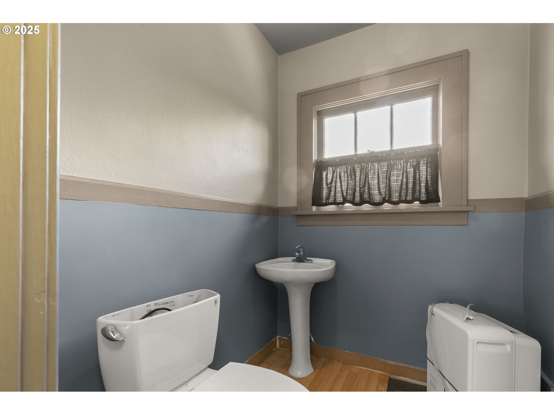 6055 East Burnside Street Portland, OR 97213 - Photo 18 of 32 a bathroom with a toilet a sink and a window