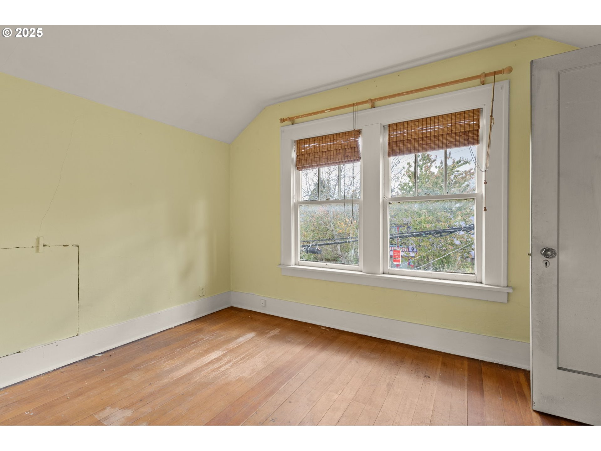 6055 East Burnside Street Portland, OR 97213 - Photo 27 of 32 a view of an empty room with wooden floor and a window