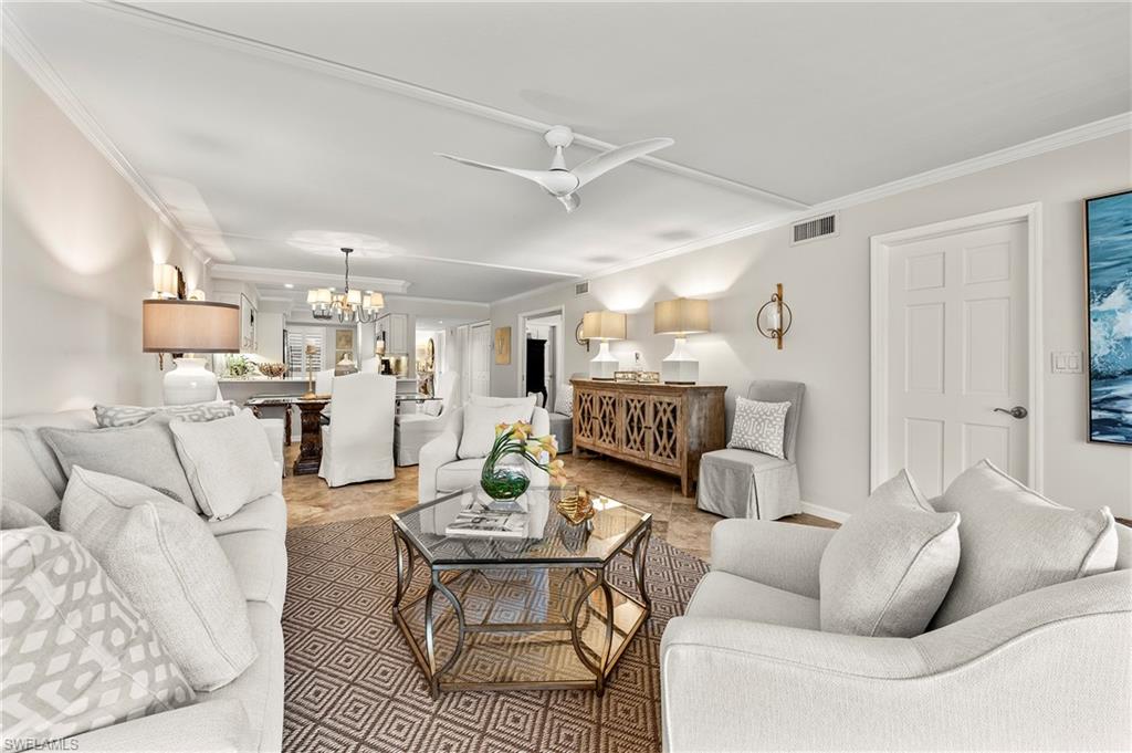 4155 Crayton Road, Unit 107 Naples, FL 34103 - Photo 12 of 36 Living room featuring ceiling fan with notable chandelier and ornamental molding