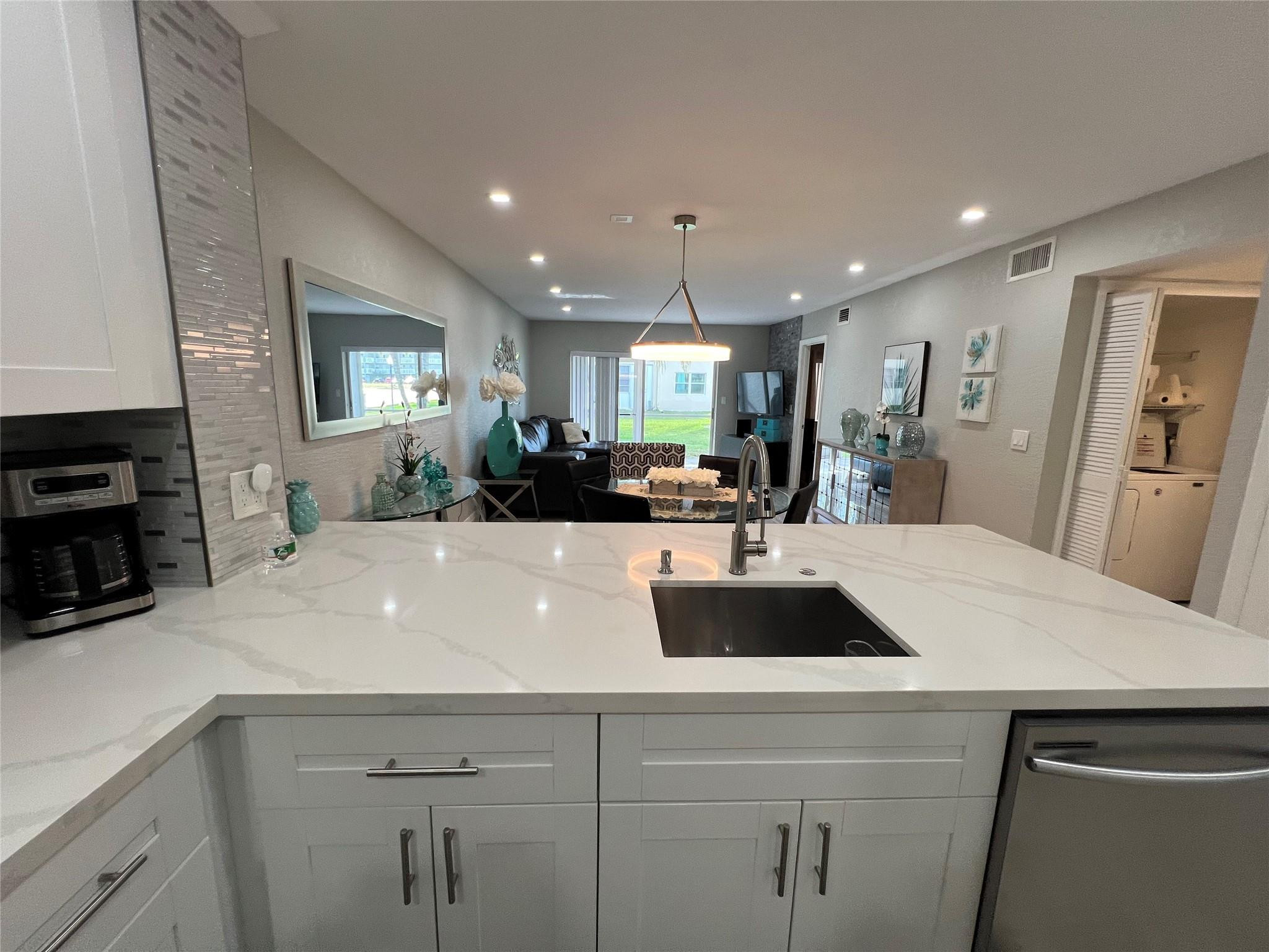 9780 Marina Boulevard, Unit 415 Boca Raton, FL 33428 - Photo 24 of 39 a view of kitchen island a sink wooden floor and living room view