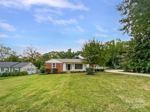 a view of a house with yard and sitting area