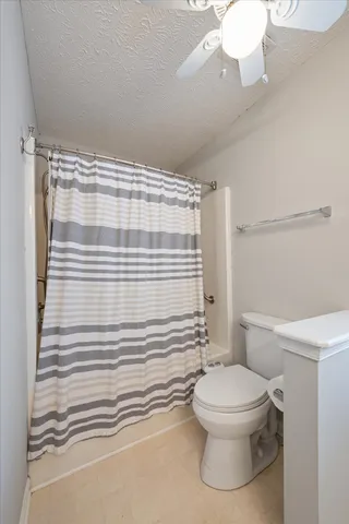 a white toilet sitting next to a bathroom sink and a shower