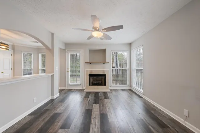 wooden floor fireplace and windows in an empty room