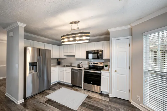a kitchen with stainless steel appliances a refrigerator a stove a sink and a center island