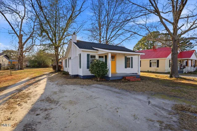 a view of a house with a yard and tree