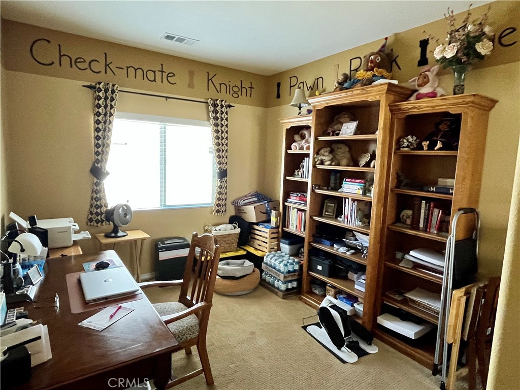1244 Katherine Court Beaumont, CA 92223 - Photo 12 of 19 a view of a workspace with furniture and a book shelf