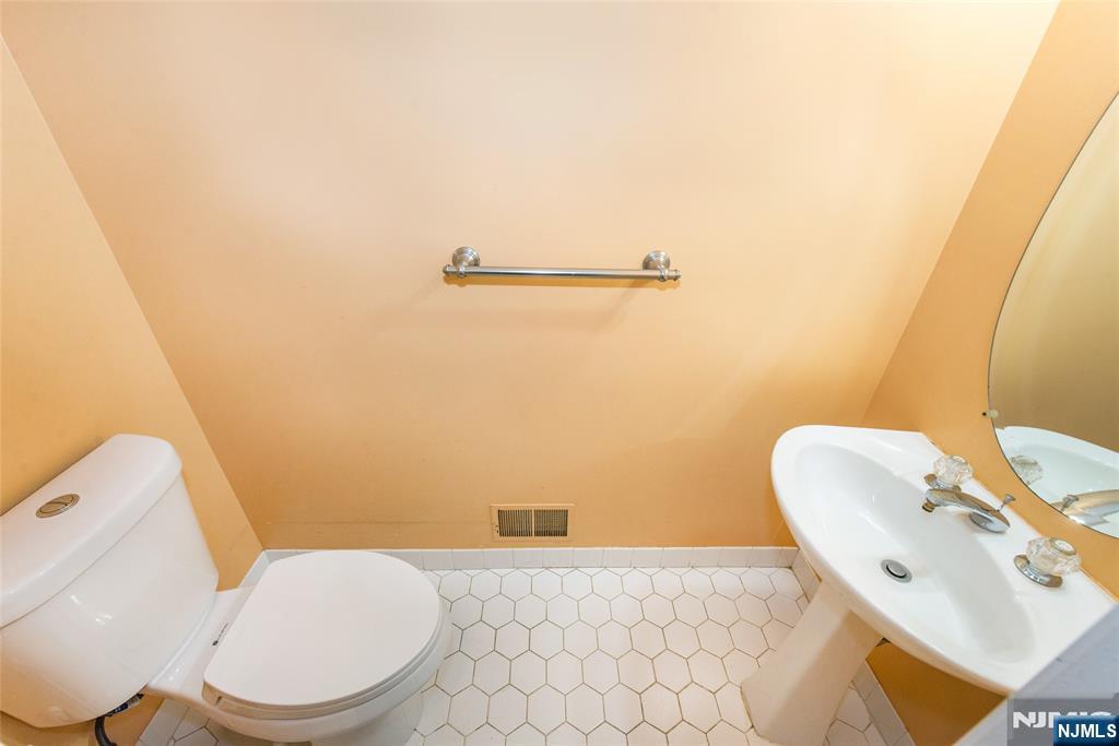 10 Gannet Court Wayne, NJ 07470 - Photo 12 of 24 a white toilet sitting next to a bathroom sink