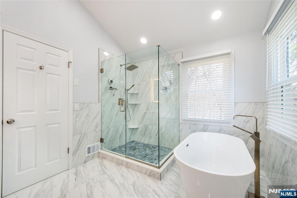 10 Gannet Court Wayne, NJ 07470 - Photo 16 of 24 a bathroom with a tub shower sink and mirror