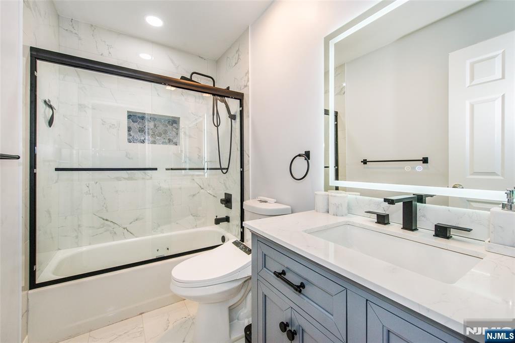 10 Gannet Court Wayne, NJ 07470 - Photo 20 of 24 a bathroom with a shower sink vanity mirror and toilet