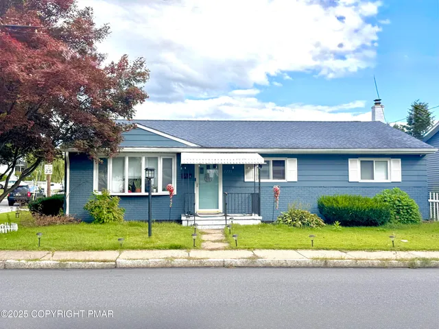 a front view of a house with a yard and potted plants