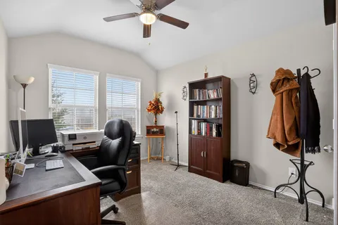 a view of a workspace with furniture and a window