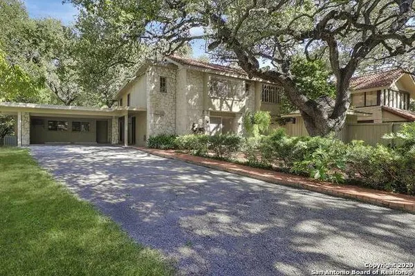 a front view of a house with garden and trees