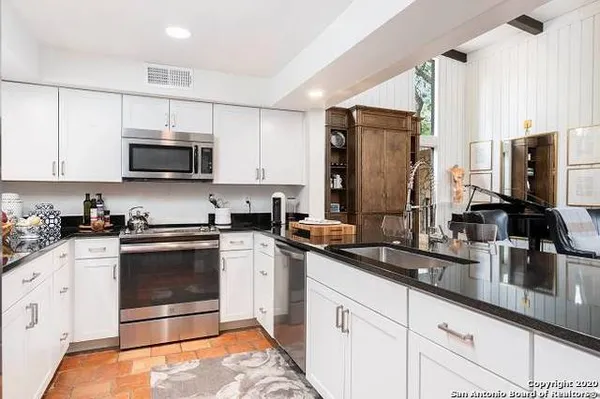 a kitchen with stainless steel appliances a stove microwave and sink