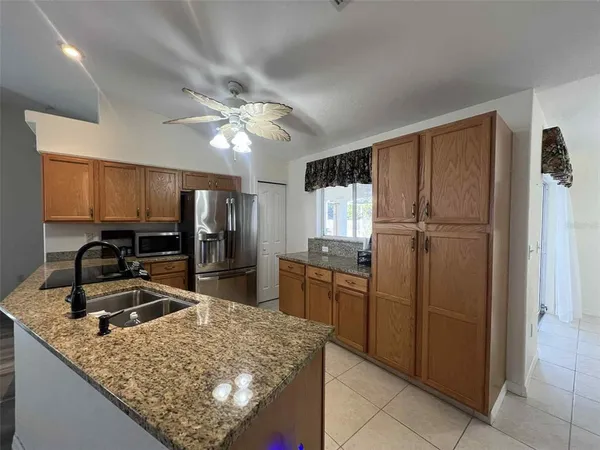 a kitchen with kitchen island granite countertop cabinets and refrigerator