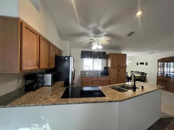 a kitchen with granite countertop a sink a counter top space and cabinets
