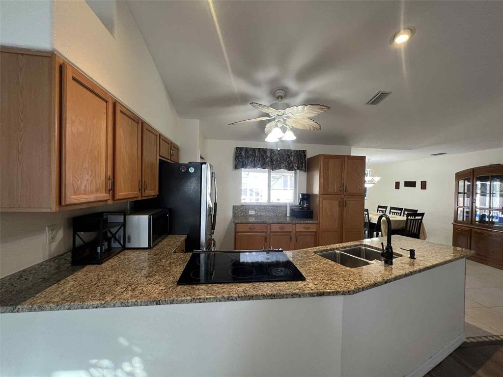 Undisclosed Address Spring Hill, FL 34608 - Photo 9 of 10 a kitchen with granite countertop a sink a counter top space and cabinets