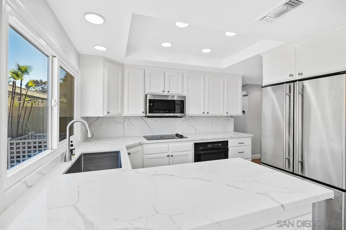 14 Dragonfly, Unit 25 Irvine, CA 92604 - Photo 11 of 29 a large white kitchen with stainless steel appliances granite countertop a refrigerator stove microwave and sink