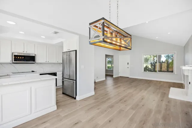 a kitchen with stainless steel appliances granite countertop a refrigerator and a stove top oven