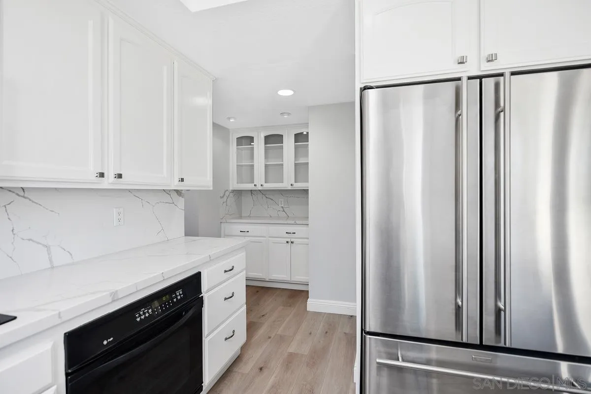 14 Dragonfly, Unit 25 Irvine, CA 92604 - Photo 14 of 29 a kitchen with white cabinets and white appliances