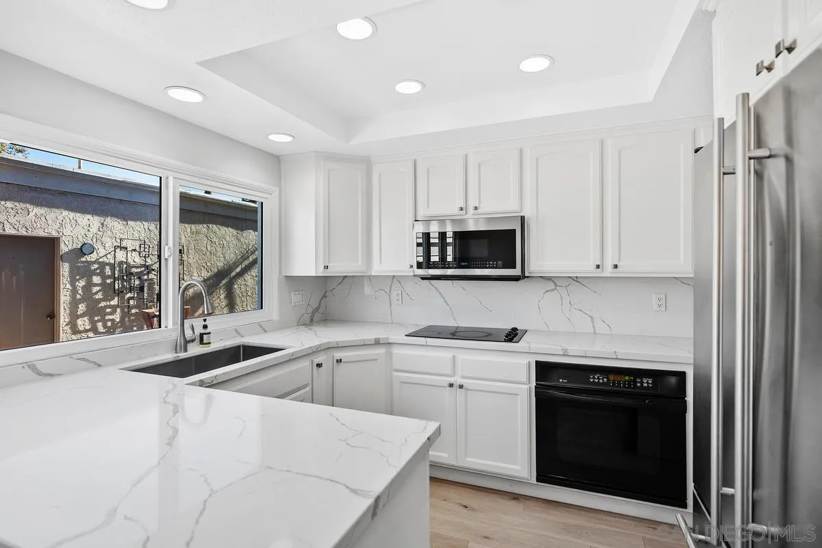 14 Dragonfly, Unit 25 Irvine, CA 92604 - Photo 15 of 32 a kitchen with stainless steel appliances granite countertop a stove a sink and a microwave
