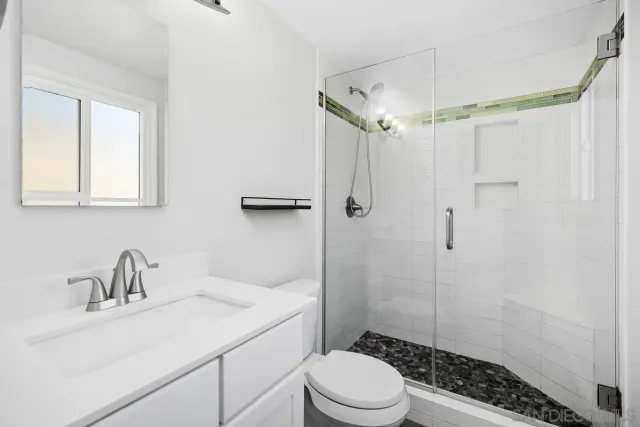 a bathroom with a sink toilet a mirror and shower