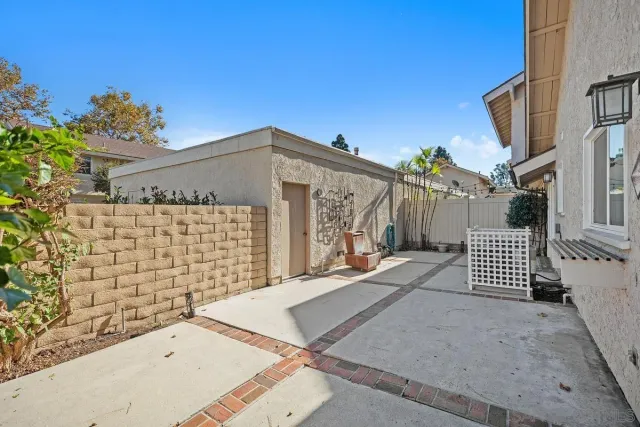 a view of a brick house with wooden fence