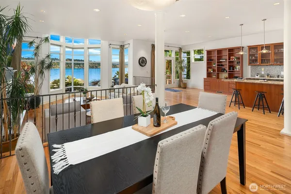 a dining room with wooden floor glass table and chairs