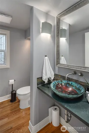 a bathroom with a granite countertop sink and a toilet