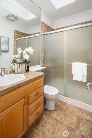 a bathroom with a granite countertop sink mirror and toilet
