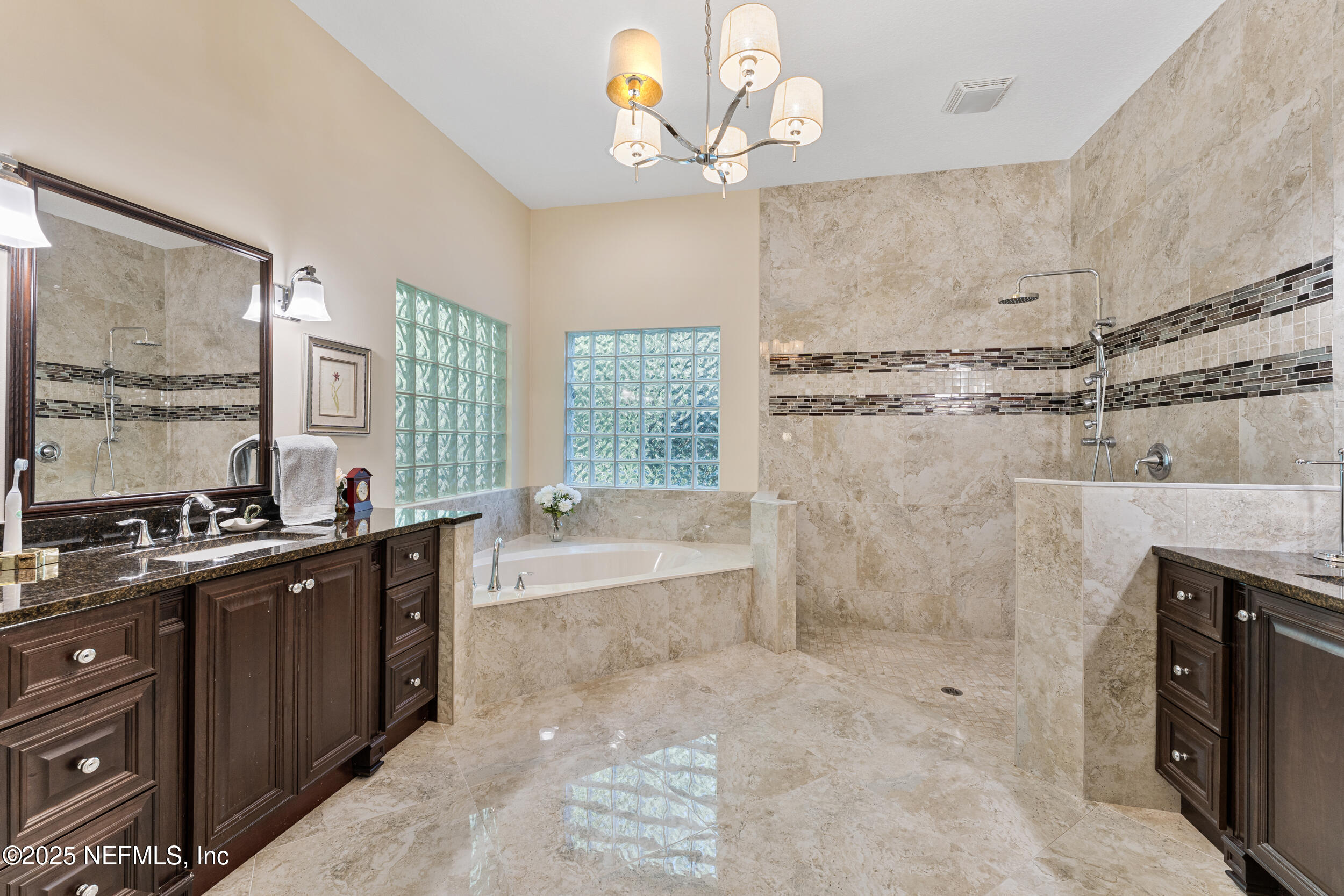 686 Frederic Drive Fleming Island, FL 32003 - Photo 25 of 57 a spacious bathroom with a granite countertop sink a large mirror and a bathtub