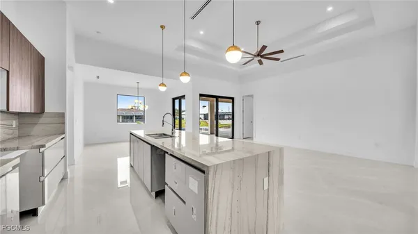 a kitchen with granite countertop a center island a stove and a chandelier