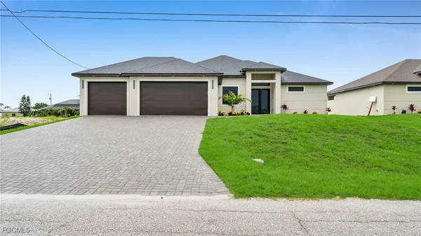 a front view of a house with a garden and yard