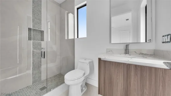a bathroom with a granite countertop sink toilet and shower