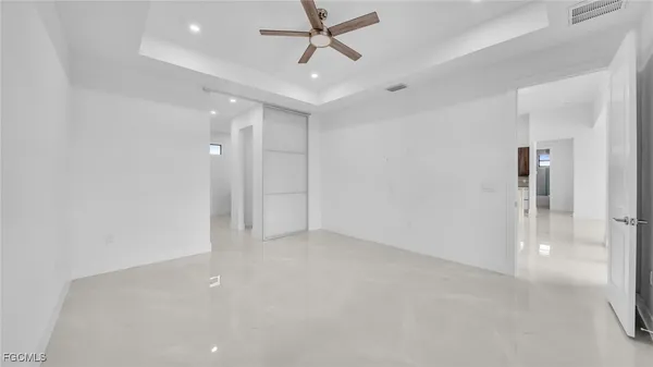 wooden floor in an empty room with a ceiling fan
