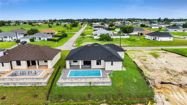 an aerial view of residential houses with outdoor space and swimming pool