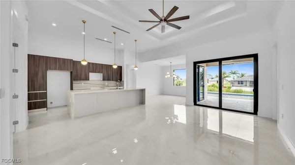a large white kitchen with a large window appliances and furniture