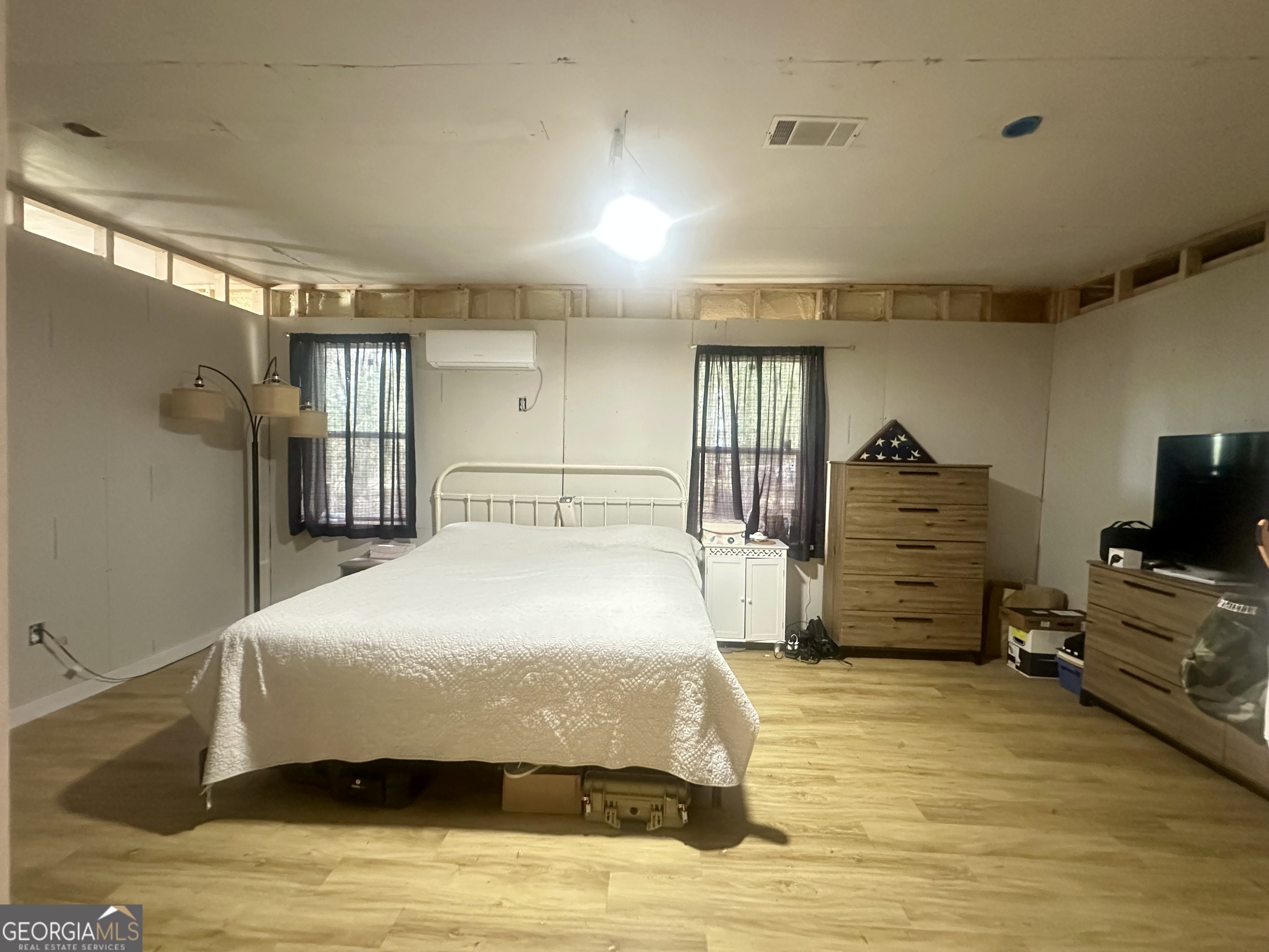 251 Bill Hambrick Road Eastman, GA 31023 - Photo 25 of 32 a spacious bedroom with a bed and a flat tv screen on wall