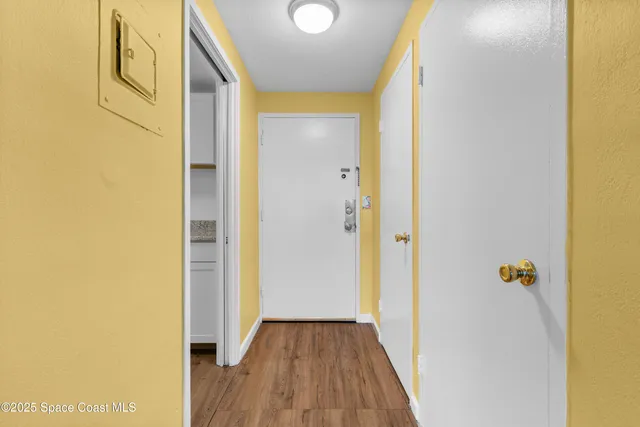 a view of a hallway with wooden floor
