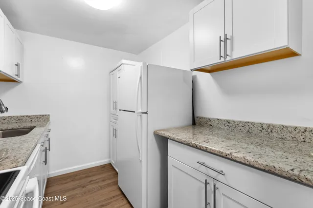a view of a storage and utility room with wooden floor