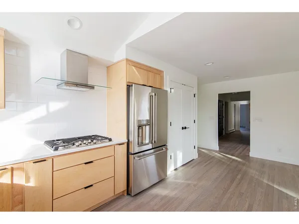 a kitchen with stainless steel appliances a refrigerator and a stove top oven