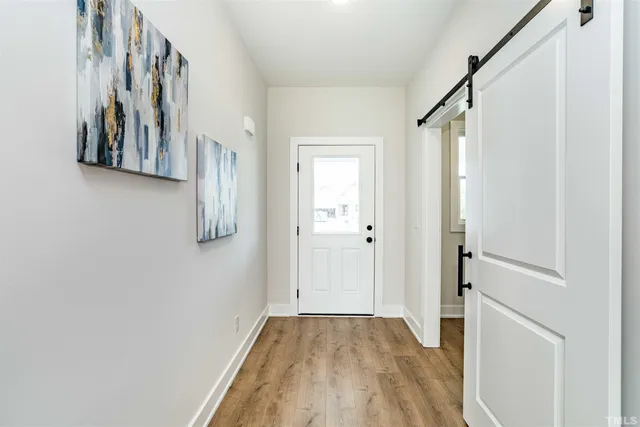 a view of a hallway with wooden floor and staircase