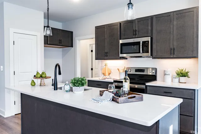 a kitchen with a sink a microwave and cabinets