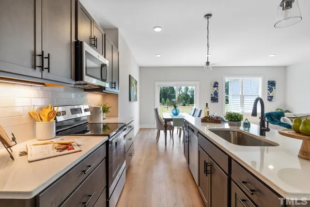 a kitchen with kitchen island a large counter top space a sink stainless steel appliances and cabinets