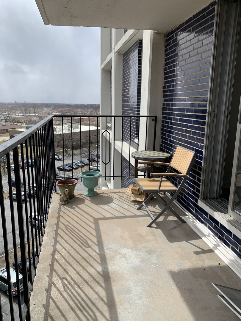 8809 Golf Road, Unit 8A Niles, IL 60714 - Photo 11 of 12 a view of a patio with a table and chairs and wooden floor