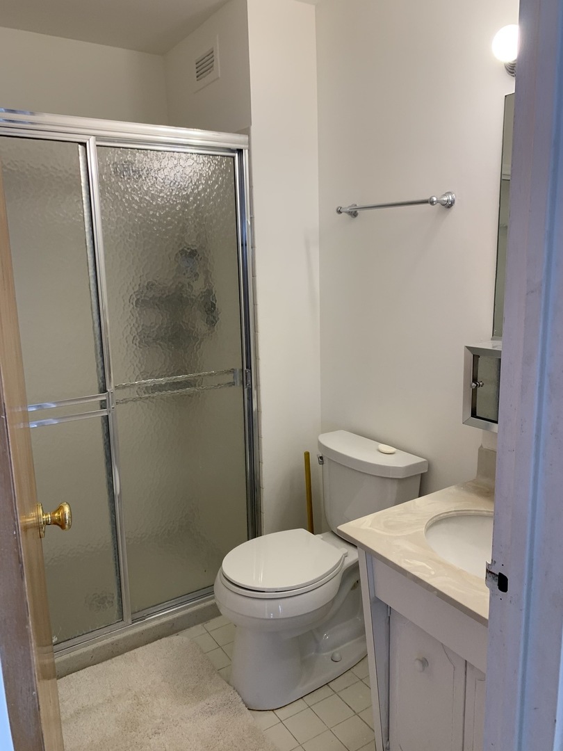 8809 Golf Road, Unit 8A Niles, IL 60714 - Photo 8 of 12 a white toilet sitting next to a shower