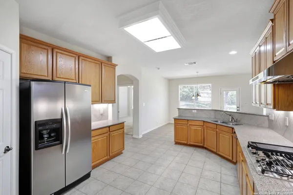 a large kitchen with stainless steel appliances granite countertop a refrigerator and a sink