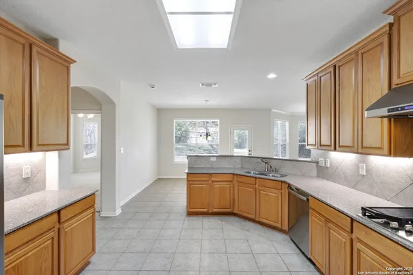 a large kitchen with stainless steel appliances granite countertop a sink and cabinets